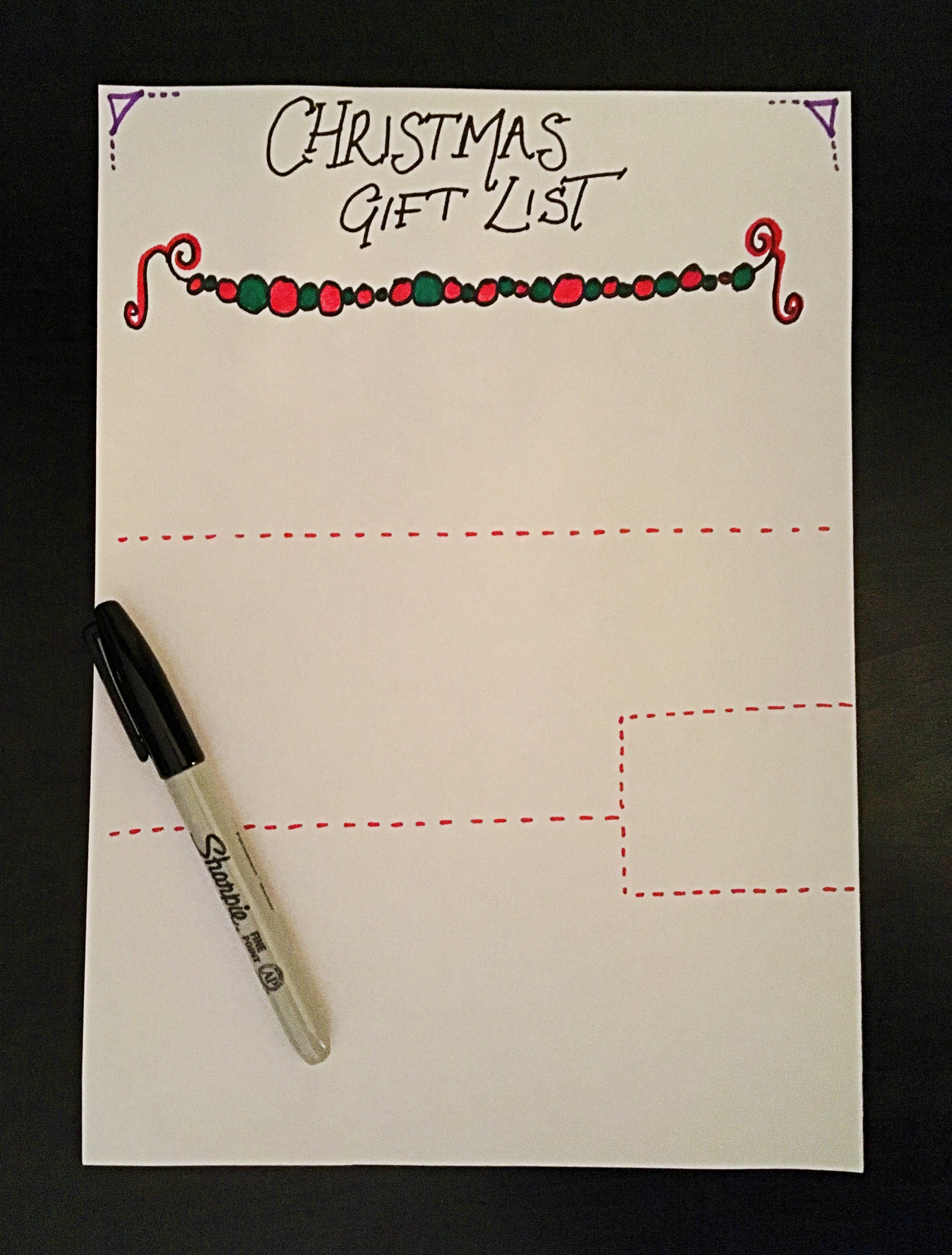 An A4 piece of paper in which I've written "Christmas Gift Lift" and decorated it in green and red. A Sharpie pen is on the paper.