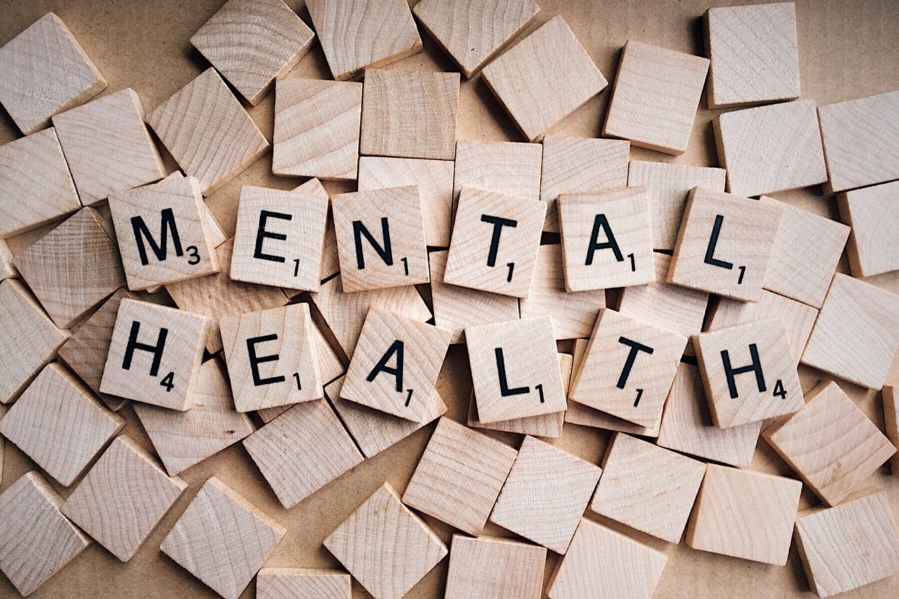 Wooden scrabble tiles on a table with 'mental health' spelled out.
