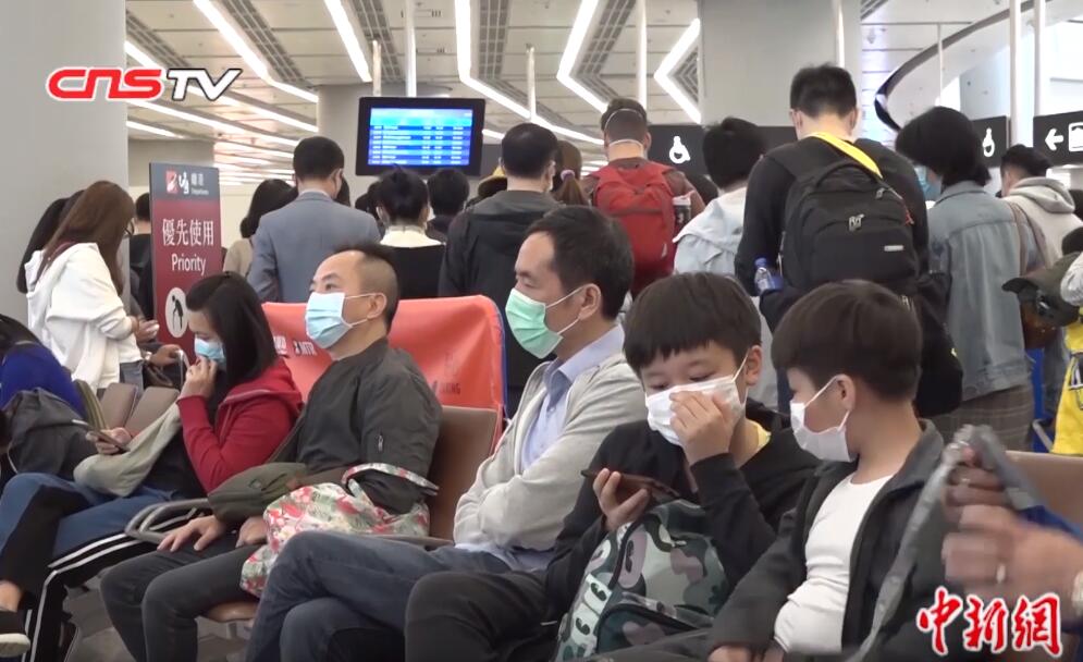 A photo of many people in an airport in China wearing face masks, with the CNSTV logo at the top as this is a Wikipedia Commons image taken from a media broadcast.