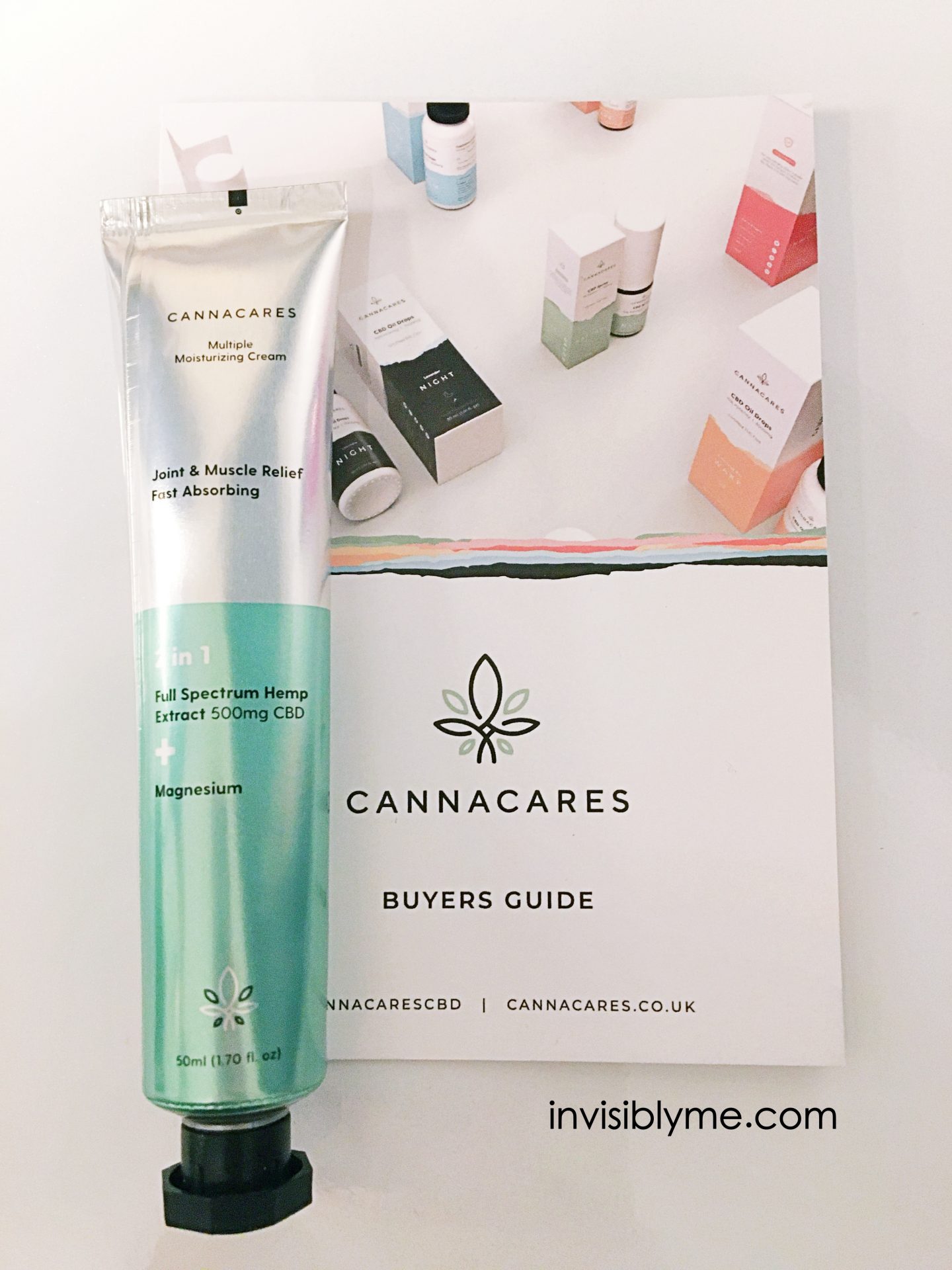 A bird's eye photo of the silver and green tube of CBD and magnesium cream from Cannacares for my review on top of the brochure.