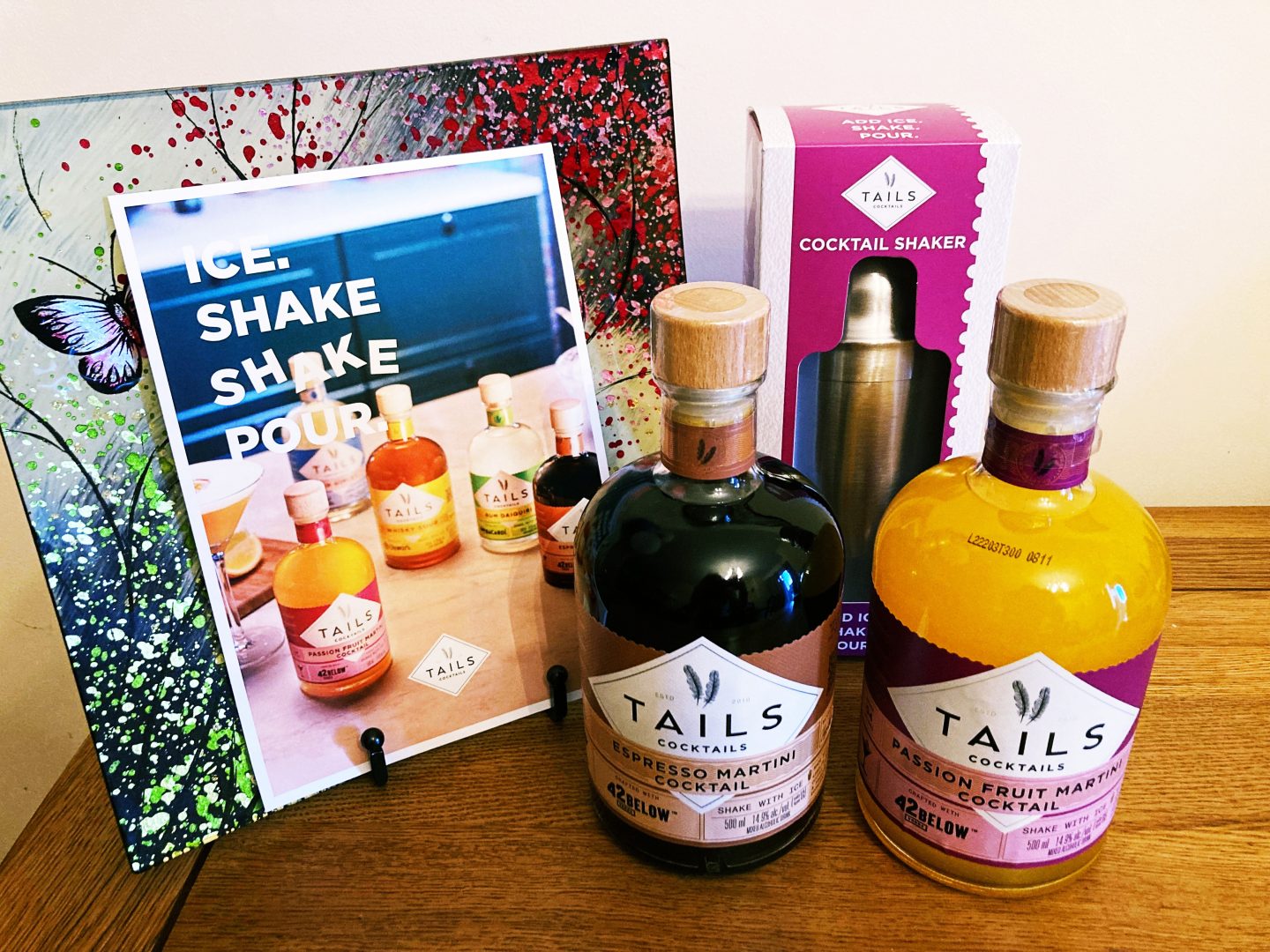 Two Tails Cocktails bottles, a cocktail shaker and a promotional leaflet.