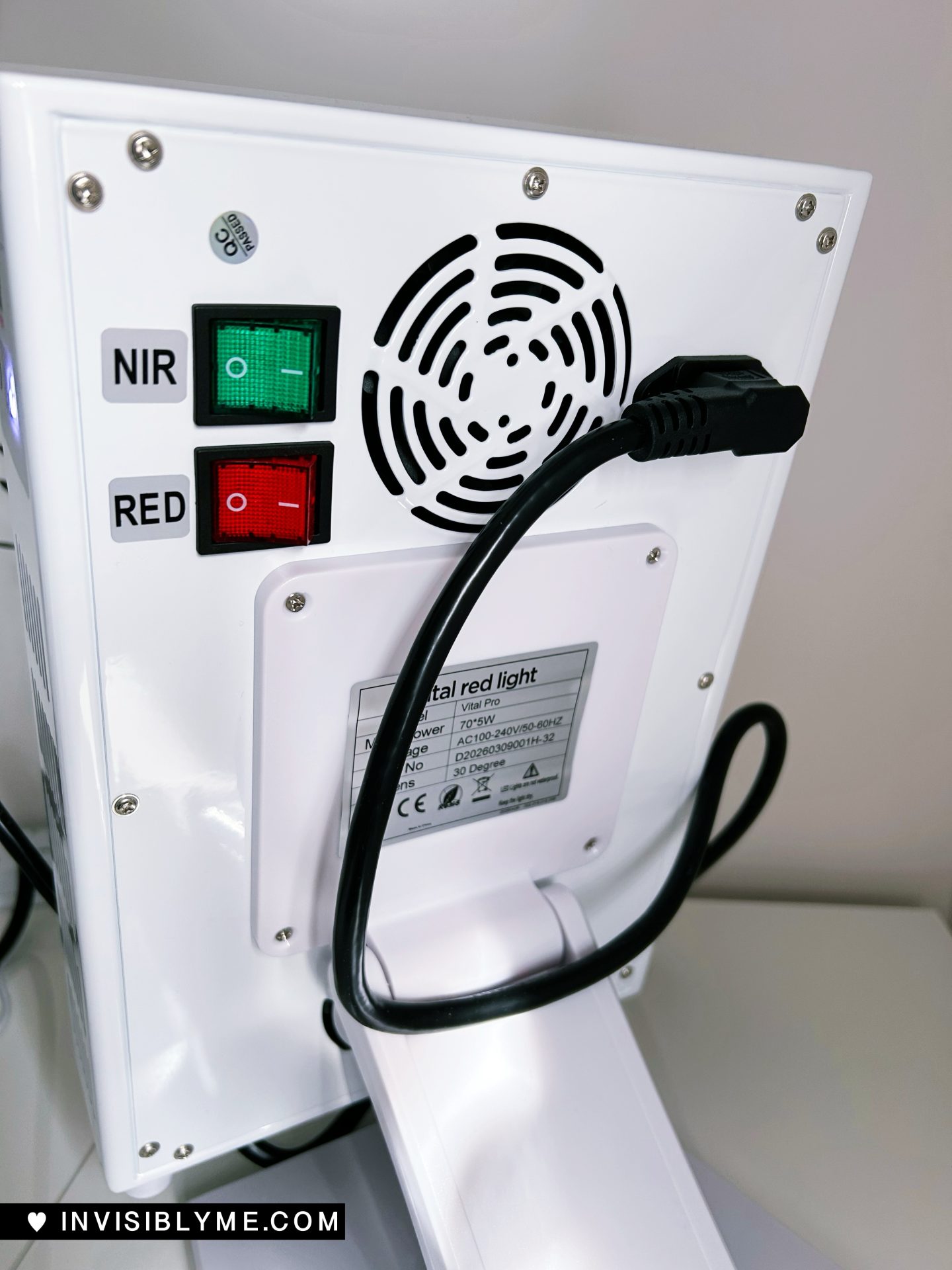 The back of the device, with a power cable in the back, holes for the fan and two switches.